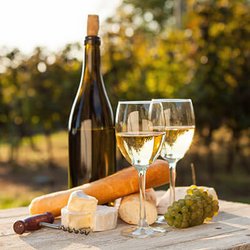 Weinflasche, Weingläser und Käsejause