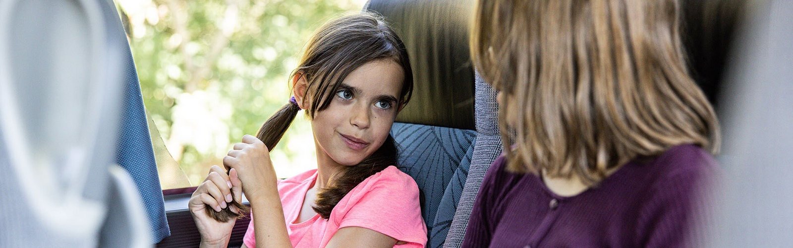 Zwei Kinder sitzen in Blaguss Bus