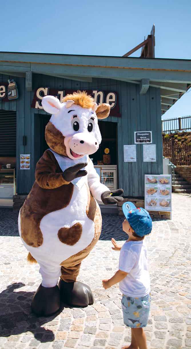 Maskottchen grüßt ein Kind