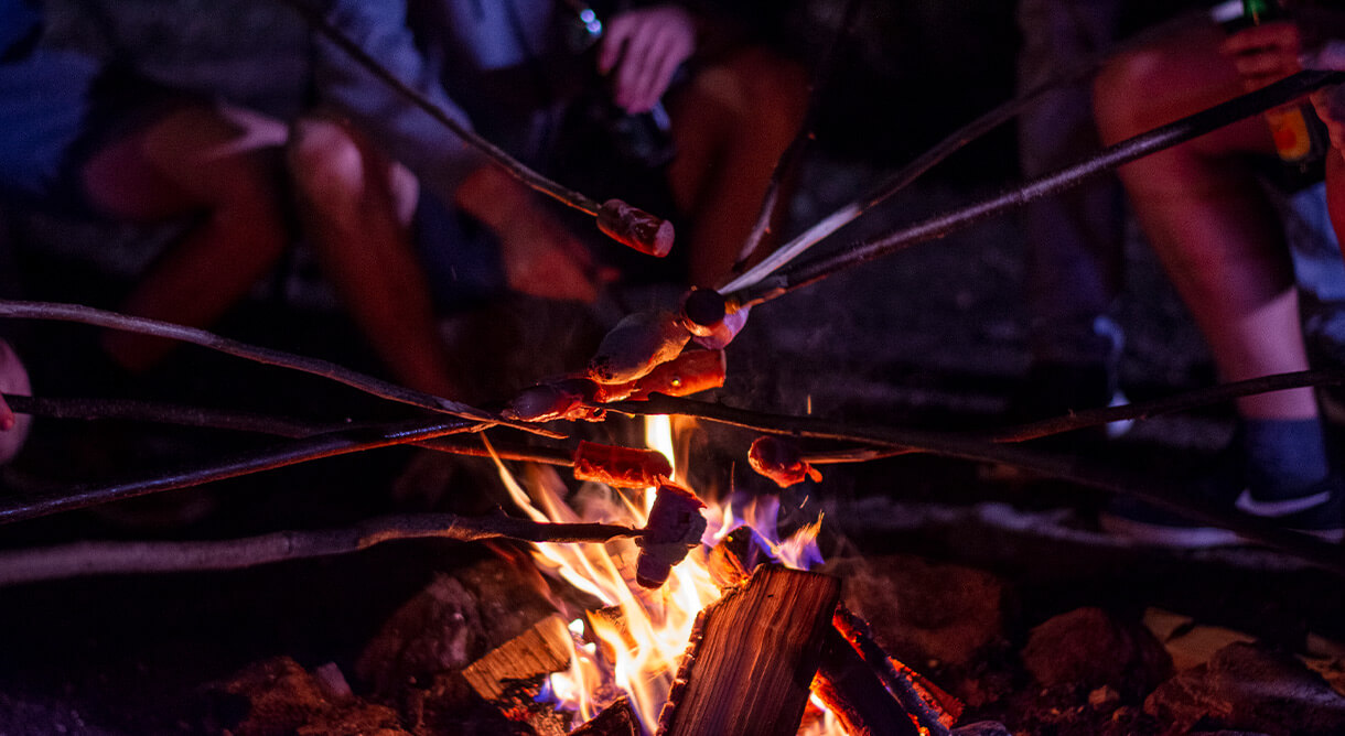 Würstel grillen über Lagerfeuer